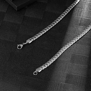 Macro detail of silver titanium steel curb chain with secure lobster clasps and polished finish