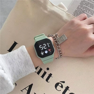 Close-up of mint green digital sports watch with astronaut icon and square LED display