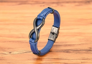 Macro detail of blue leather men's bracelet with black infinity charm and steel clasp