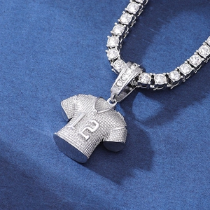 Close-up of silver jersey pendant with number 12 and iced-out tennis chain jewelry
