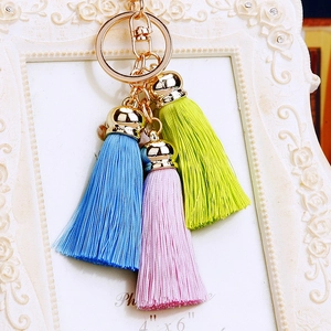 Detail of three-color pastel silk tassels with golden metal clasp and ring attachment
