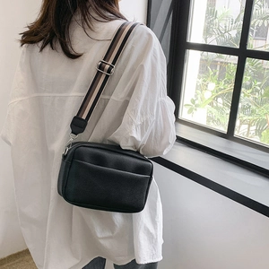 Sac bandoulière tendance en cuir grainé noir avec large bandoulière en tissu rayé réglable