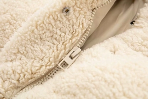 Gros plan sur la polaire sherpa beige avec détails de fermeture éclair métallique