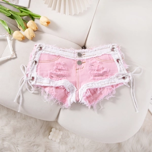 Detalle de los shorts vaqueros rosas con cordones laterales, ribete blanco y flecos