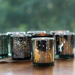 Silver and gold Christmas glass candle holders with reindeer and snowflake patterns