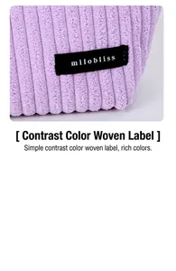 Detailed macro view of purple corduroy fabric texture with a black milobliss brand label