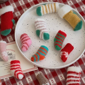 Close-up of assorted mini knitted Christmas socks with striped patterns on festive table