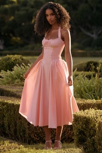 Close-up of pink floral print halter neck dress with corseted waist and pleated skirt details