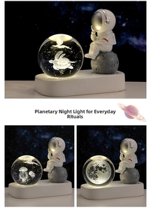 Dettaglio della lampada notturna sfera di cristallo incisa in 3D con statuetta astronauta