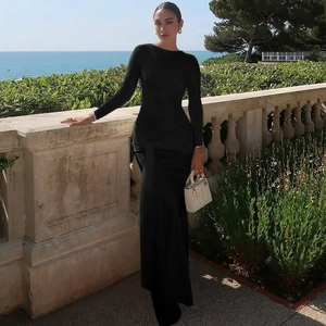 Detail view of the elegant twist knot pleat waist design on a black maxi dress