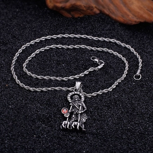 Detailed view of vintage silver shepherd pendant with red gemstone on a twisted rope chain
