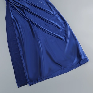 Detail of star blue satin evening dress with side slit and sparkling rhinestone accents