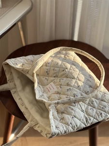 Gros plan du sac fourre-tout matelassé en velours à fleurs avec texture douce et motif