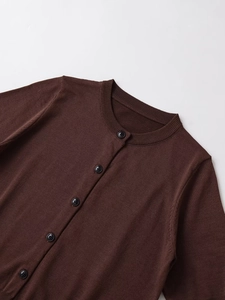 Detailed macro view of the fine-knit dark brown cardigan with five black glossy buttons