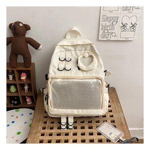 Detail of off-white backpack featuring heart-shaped window and mesh front pocket