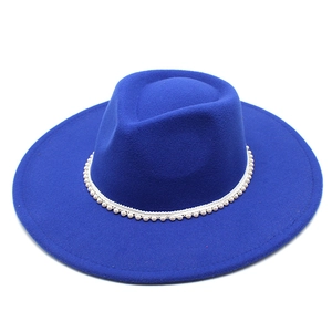 Detailed view of royal blue fedora hat featuring white pearl beaded decorative band