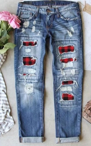 Détails d'un jean bleu déchiré avec doublure en tissu à carreaux rouge et noir