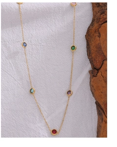 Macro shot of gold-plated thin chain necklace featuring seven multi-colored zircons