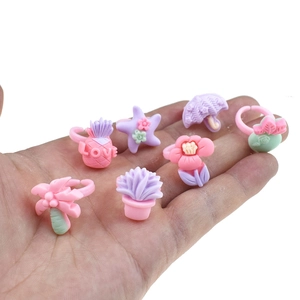 Close-up of seven colorful cartoon plastic rings for girls held in hand for size display
