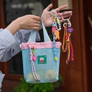 Blue mesh tote bag with a colorful beaded LOVE YA keychain shown in outdoor setting