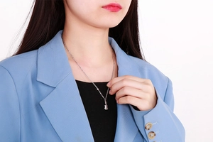 Vue détaillée d'un collier pendentif violon argenté porté par un mannequin féminin