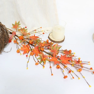 Close-up of autumn garland featuring gradient maple leaves, pumpkins and berries