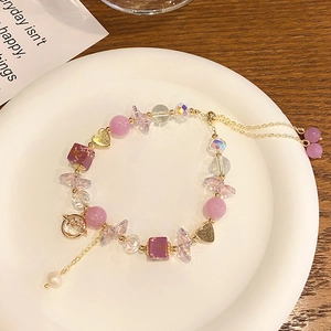 Detail of sweet purple amethyst planet bracelet with heart charms and crystal beads