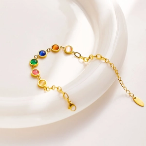 Detailed shot of gold stainless steel bracelet featuring six colorful cat-eye gemstones