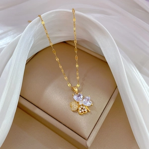 Close-up of gold clover jewelry set with sparkling crystals on white silk background