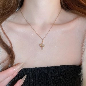 Dettaglio macro della collana con croce e zirconi scintillanti su un collo femminile
