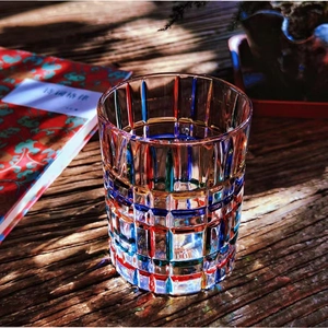 Detail of colorful hand-painted lattice glass on a rustic wood surface with warm lighting