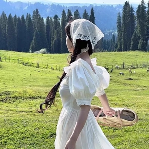 Detail of white lace triangle bandana headscarf for women styling in a pastoral meadow