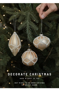 Champagne gold Christmas ball ornaments with white pearls hanging on a tree