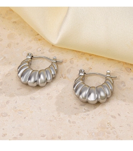 Detail of silver twisted hoop earrings with a textured croissant design on fabric