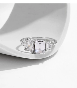Vue macro d'une bague en argent à coupe émeraude avec pierres marquises sur fond blanc