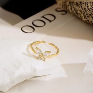 Macro shot of S925 hallmark on gold butterfly ring with white zircon stones