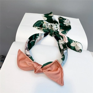 Detail of floral satin headband with pink bow and long elegant ribbons for women