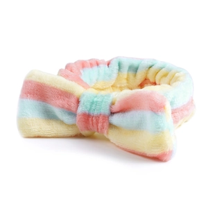 Detailweergave van zachte regenboog gestreepte pluche hoofdband met grote koraalvlies strik