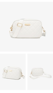 Detail view of white quilted camera bag featuring gold hardware and fabric strap