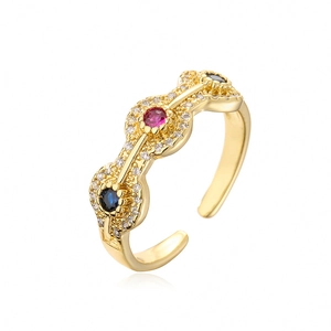 Detail of gold rainbow zircon ring with wave band and inlaid red and blue gemstones