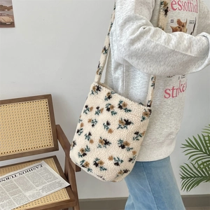 Fashionable off-white plush shoulder bag with floral print worn by model in an aesthetic room