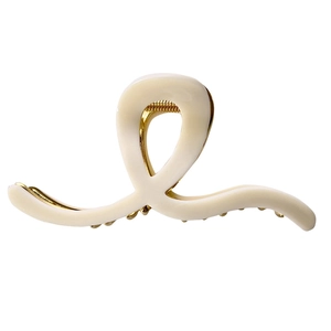 Elegant cream twisted resin hair claw clip with golden metal spring on white background