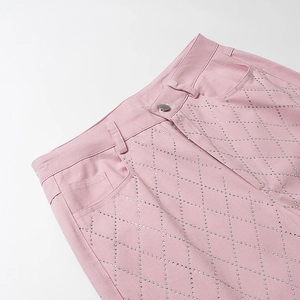 Gros plan du pantalon Y2K rose avec motifs de strass en losange et bouton métallique