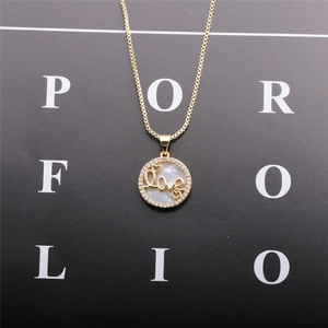 Dettaglio della collana d'oro con pendente Love tondo in madreperla e alone di zirconi