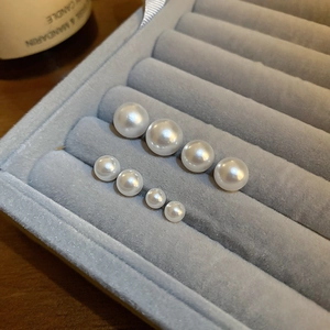 Macro shot of various pearl sizes for elegant stud earrings on velvet tray