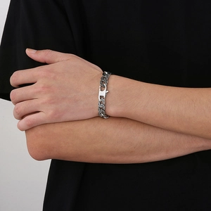 Close-up of silver Cuban link bracelet with oxidized pattern on male wrist