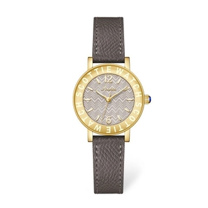 Detailed view of women's vintage gold watch featuring grey herringbone dial and blue crown