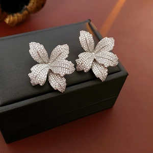Nahaufnahme von Blumen-Silberohrsteckern mit Zirkonia-Steinen in einer schwarzen Box