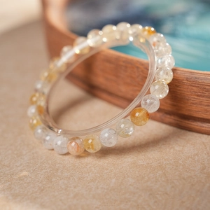 Gros plan d'un bracelet en perles de quartz jaune naturel sur un support chic