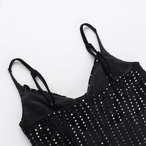 Detail of black sequined velvet fabric and delicate strap stitching on an elegant dress